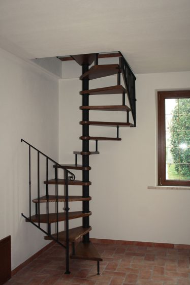 Scala a chiocciola in legno con ringhiera in metallo nero